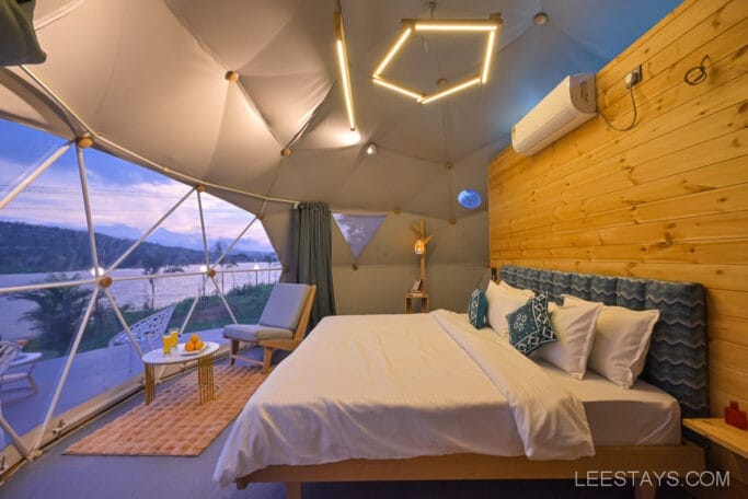 Luxury domed room interior at Domestory Resort with scenic views of Malvandi Lake, featuring a cozy bed, modern decor, and large windows overlooking the picturesque landscape.